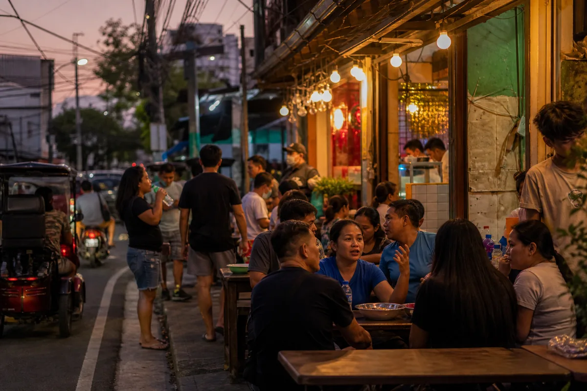 Evening street life in Manila with people at a neighborhood café
